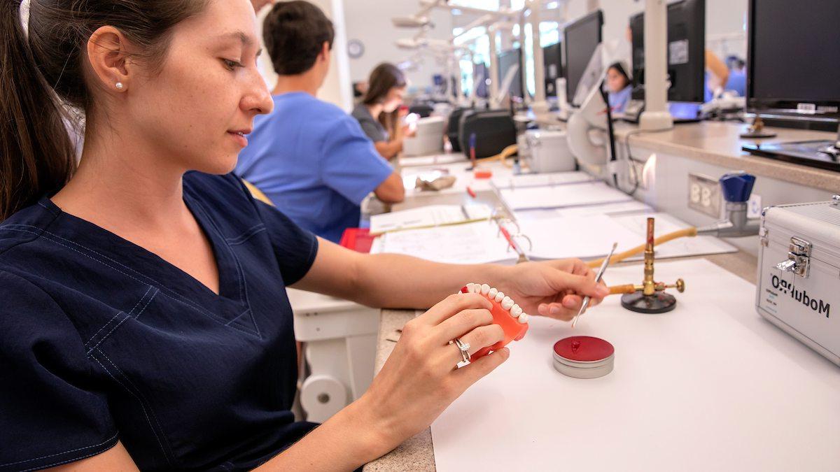 A dental student works in a lab.